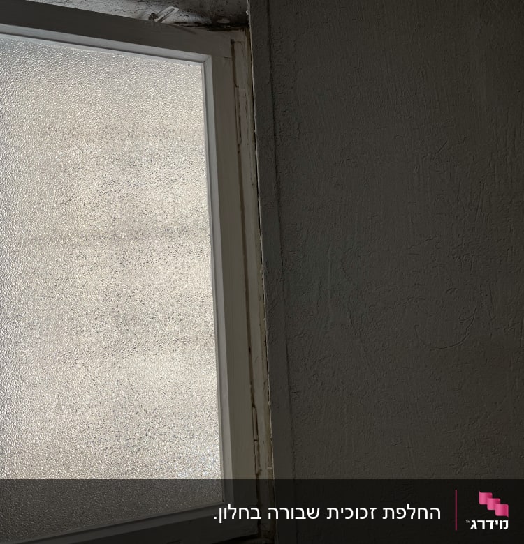חלון זכוכית מחוספסת במסגרת לבנה